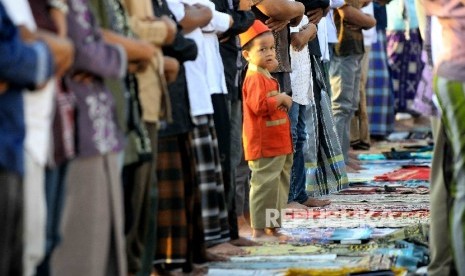 Seorang anak mengikuti shalat berjamaah