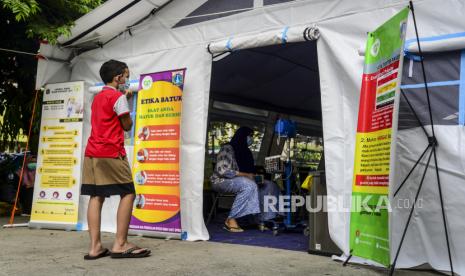 Seorang anak menunggu orang tuanya saat dicek kondisi kesehatannya di tenda darurat Covid-19 di RSUD Kramat Jati, Jakarta, Jumat (25/6). Lonjakan kasus Covid-19 membuat beberapa rumah sakit di Jakarta menyiapkan tenda darurat untuk mengecek kesehatan kondisi pasien terlebih dahulu sebelum dirujuk ke IGD atau menjalani rawat inap. 