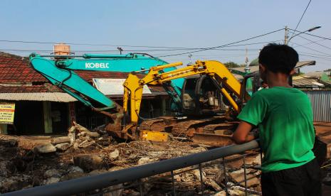 Seorang anak menyaksikan proses pembongkaran Jembatan Cibubur di Ciracas, Jakarta Timur, Sabtu (6/8/2022). Revitalisasi jembatan penghubung wilayah Pasar Rebo dan Ciracas tersebut untuk menghindari genangan ketika Sungai Cipinang meluap. 