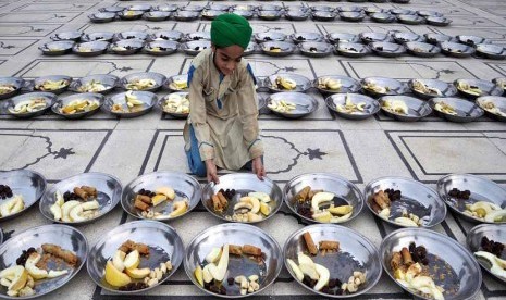  Seorang anak menyiapkan hidangan buka puasa di Karachi, Pakistan, Kamis (11/7).   (EPA / Shahzaib Akber)