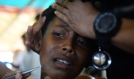 Seorang anak pengungsi Rohingya diperiksa lukanya oleh tenaga medis di tenda kesehatan Indonesia, Kamp Pengungsian Jamtoli, Cox's Bazar, Bangladesh. 