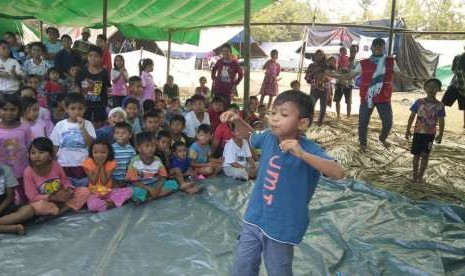 Seorang anak pengungsi saat mengikuti lomba kelereng.