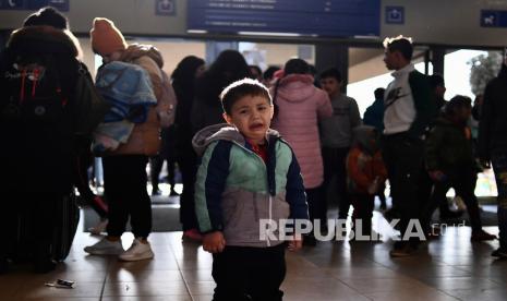  Seorang anak pengungsi yang melarikan diri dari konflik dari negara tetangga Ukraina menangis di stasiun kereta api setelah tiba di Zahony, Hongaria, Ahad, 27 Februari 2022. Pertempuran jalanan pecah di kota terbesar kedua di Ukraina pada hari Ahad dan pasukan Rusia meningkatkan tekanan pada pelabuhan-pelabuhan strategis di selatan negara itu menyusul gelombang serangan terhadap lapangan terbang dan fasilitas bahan bakar di tempat lain yang tampaknya menandai fase baru invasi Rusia. 