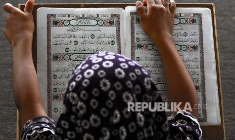 Seorang anak perempuan membaca Alquran di Masjid Usman bin Affan, Khan Younis di Jalur Gaza, Palestina.