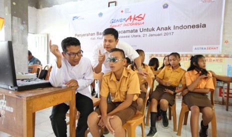  Seorang anak sedang diperiksa matanya oleh petugas refraksi didampingi Kepala Divisi Kesehatan Rumah Sakit dan Sosial PMI Pusat dr. Arfan 