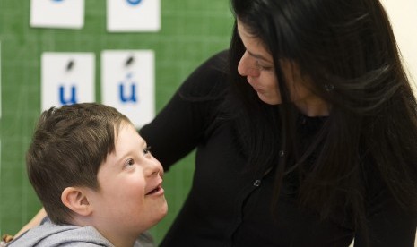 Seorang anak sindroma down sedang memeluk gurunya di sekolah di Budapest, Hungaria.