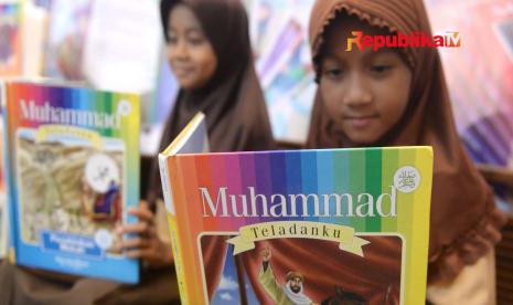 Seorang anak tengah membaca buku kisah Nabi Muhammad SAW