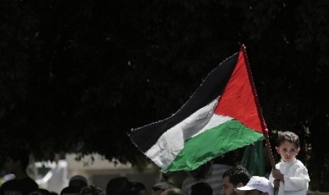 Seorang anak tengah memegang bendera Palestina di Gaza. 