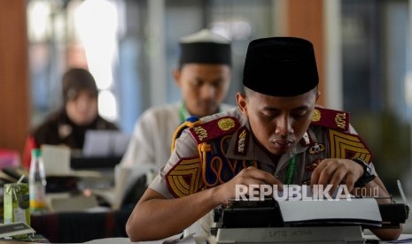 Seorang anggota Akademi Kepolisian dari Jawa Tengah Farhan Arif mengikuti semi final lomba Musabaqah menulis makalah ilmiah Al Quran dalam rangkaian MTQ Nasional ke XXVI yang diadakan di Gedung Irigasi PU Kota Mataram, Nusa Tenggara Barat, Selasa (2/8). (R