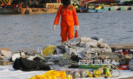 Seorang anggota Basarnas memeriksa puing pesawat Lion Air JT 610 pascakecelakaan,di Pelabuhan Tanjung Priok Jakarta, Senin (29/10/2018).