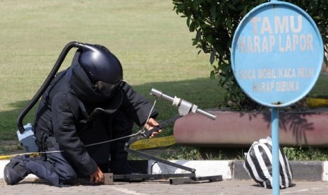 Seorang anggota dari tim Gegana Polda DIY saat akan meledakkan sebuah bungkusan plastik diduga bom yang diletakan oleh seseorang tak dikenal di Polda DIY, Jumat (13/4). Setelah diledakkan ternyata isi bungkusan plastk tersebut berisi beberapa bahan makanan