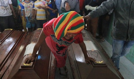 Seorang anggota keluarga korban awan panas erupsi Gunung Sinabung menangis didekat peti jenazah, sebelum dimakamkan di Desa Sukandebi, Karo, Sumatera Utara, Minggu (22/5).