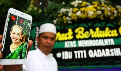 Seorang anggota keluarga menunjukan foto semasa hidup almarhumah Titi Qadarsih di rumah duka di Sawangan, Depok, Jawa Barat, Senin (22/10/2018). Titi Qadarsih yang merupakan penyanyi dan aktris film senior Indonesia meninggal dunia dalam usia 73 tahun pada Senin (22/10) karena sakit. 