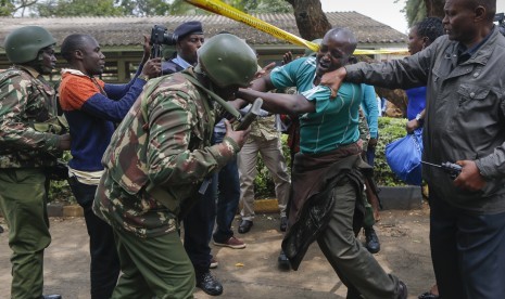 Seorang anggota keluarga siswa didorong oleh petugas polisi saat ia menuntut untuk melihat sisa-sisa tubuh putrinya di Sekolah Khusus Perempuan Moi di Nairobi, Kenya, Sabtu (2/9). Tujuh siswa telah terbunuh dan belasan lebih terluka saat kebakaran membakar sebuah asrama di Sekolah Khusus Perempuan Moi pada Sabtu.