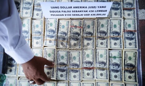 Seorang anggota kepolisian menunjukan uang dolar palsu. (Republika/Raisan Al Farisi)