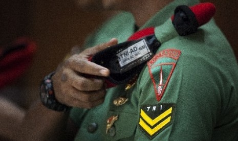 Seorang anggota Kopassus Grup II Kandang Menjangan Kartasura terdakwa kasus penyerangan tahanan Lapas 2B Cebongan memegang baret merahnya ketika menjalani sidang militer lanjutan di Pengadilan Militer II-11 Yogyakarta, Bantul, Yogyakarta, Senin (24/6).