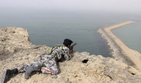 Seorang anggota militer Iran mengambil posisi siaga di pengeboran minyak Iran di pantai laut Oman. 