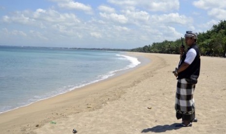 Seorang anggota Pecalang atau satuan pengamanan adat Bali berkomunikasi dengan rekannya saat memantau situasi pantai saat pelaksanaan Hari Raya Nyepi di Pantai Kuta, Bali, Senin (31/3).