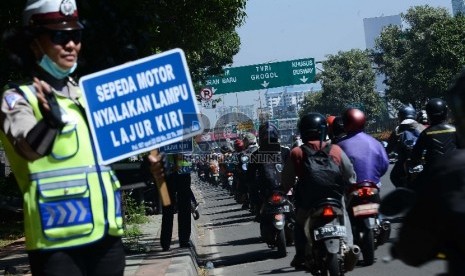 Seorang anggota Polisi mengatur lalu lintas di Jalan Gatot Subroto, Jakarta Selatan.