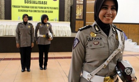 Seorang anggota Polwan memperlihatkan model seragam dinas berjilbab saat sosialisasi penggunaan jilbab bagi Polwan dan PNS di Mapolda Sumatera Utara, Medan, Kamis (2/4). 