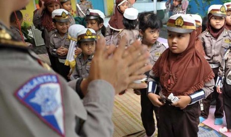  Seorang anggota Polwan tengah berinteraksi dengan siswa siswi TK.