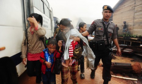  Anggota Brimob Polda Kalbar mendampingi warga eks-Gafatar saat dievakuasi dari permukiman mereka yang dibakar massa di kawasan Monton Panjang, Dusun Pangsuma, Desa Antibar, Mempawah Timur, Kabupaten Mempawah, Selasa (19/1).(Antara/Jessica Helena Wuysang)