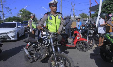 Seorang anggota Satlantas Polresta Kupang Kota mendorong satu unit kendaraan roda dua berknalpot tidak standar saat menggelar razia kendaraan bermotor dalam Operasi Zebra Turangga 2022 di Kota Kupang, NTT, Jumat (7/10/2022). Terhitung sejak Senin (3/10) sampai Jumat (7/10) hari ini sudah terjaring 162 kendaraan bermotor dalam operasi Zebra Turangga 2022 dengan rincian 112 kendaraan roda dua dan sisanya kendaraan roda empat dengan terbanyak pelanggaran adalah knalpot tidak standar serta tak bisa menunjukkan surat-surat kendaraan bermotor. 