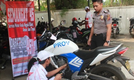 Seorang anggota TNI/Polri terlihat sedang memakai jasa servis di bengkel resmi Honda.