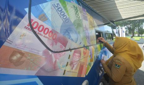 Seorang Aparatur Sipil Negara (ASN) menukarkan uang lamanya dengan uang baru emisi 2022 di mobil kas keliling Bank Indonesia di Padang, Sumatra Barat, Selasa (20/9/2022) (ilustrasi). Bank Indonesia (BI) akan memastikan ketersediaan uang rupiah layak edar melalui program Semarak Rupiah Ramadhan dan Berkah Idul Fitri (Serambi) 2023. 