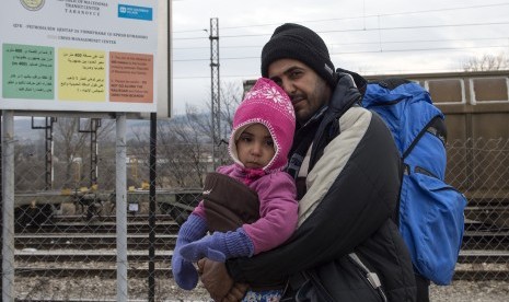 Seorang ayah dan anaknya merupakan pengungsi dari Suriah, berjalan menuju perbatasan Serbia dari pusat transit bagi para pengungsi di dekat desa Tabanovce, Kumanovo, Republik Yugoslavia, (4/2). 