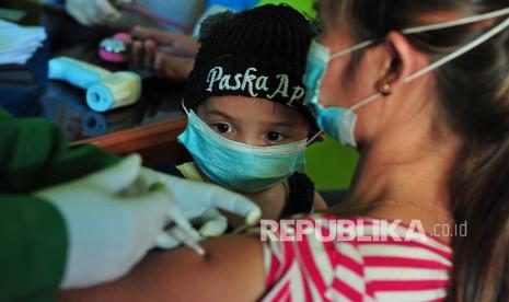 Seorang balita melihat ibunya menerima suntikan vaksin COVID-19 dosis pertama dari tenaga kesehatan saat vaksinasi massal di Kantor Pemerintah Desa Sungai Dayo, Bahar Utara, Muarojambi, Jambi, Kamis (12/8/2021). Pemberian vaksin bagi sejumlah warga kepada sekitar 40 kepala keluarga Suku Anak Dalam di desa yang berjarak sekitar 100 kilometer dari pusat Pemerintah Kabupaten Muarojambi itu bertujuan menghambat perluasan sebaran virus dan sekaligus memperluas jangkauan vaksinasi hingga ke pelosok.