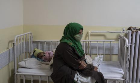 Seorang bayi perempuan tidur di tempat tidur di samping ibunya saat dia menjalani perawatan di bangsal gizi buruk Rumah Sakit Anak Nasional Ataturk di Kabul, Afghanistan, Kamis, 2 Desember 2021. 