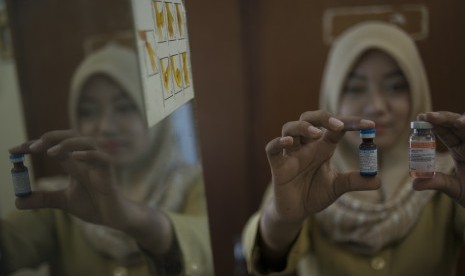 Seorang bidan menunjukkan vaksin campak dan vaksin bcg yang asli di Puskesmas Kecamatan Sawah Besar, Jakarta, Selasa (28/6). 