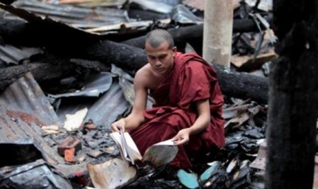 Seorang biksu Buddha Bangladesh memeriksa sisa-sisa buku agama yang terbakar habis bersama kuil Buddha dalam serangan hari Sabtu dan Minggu di Ramu, wilayah Cox's Bazar, Bangladesh (1/10).