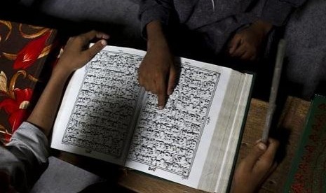 Seorang bocah belajar membaca Alquran (ilustrasi)