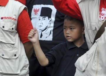 Seorang bocah berada di antara sejumlah anggota PDIP mengikuti upacara bendera memperingati Hari Kelahiran Pancasila di DPP PDIP, Lenteng Agung, Jakarta, Rabu (1/6).