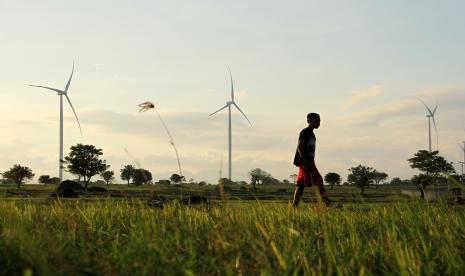 Seorang bocah berjalan di dekat kawasan Pembangkit Listrik Tenaga Bayu (PLTB) Tolo di Kabupaten Jeneponto, Sulawesi Selatan, Sabtu (23/7/2022). Huawei menjalin kolaborasi sediakan energi baru terbarukan dengan harga terjangkau. Ilustrasi.