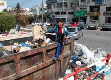 Seorang bocah di Jalur Gaza mencari nafkah sebagai tukang pengangkut sampah.