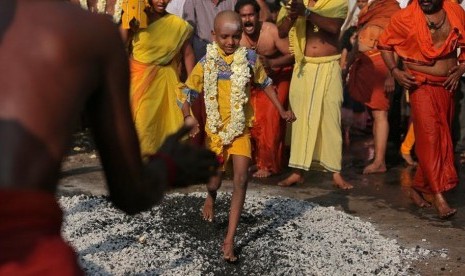 Seorang bocah lelaki plontas berjalan do atas bara api dalam acara Perayaan Thaipusam di Chennai.