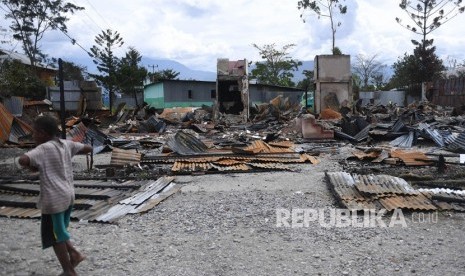 Seorang bocah melintas di depan rumah yang terbakar di kawasan Homhom, Kota Wamena, Kabupaten Jayawijaya, Papua, Kamis (10/10/2019). 