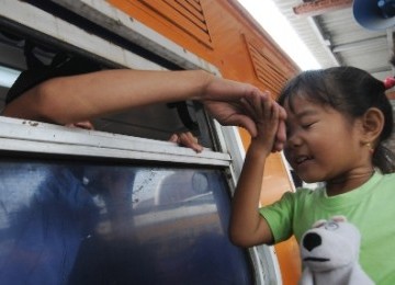 Seorang bocah mencium tangan saudaranya yang akan pergi menggunakan kereta api kelas ekonomi Gaya Baru di Stasiun Jakarta Kota, Jakarta Barat, Senin (22/8). Mulai 23 Agustus hingga 3 September 2011, kereta api kelas ekonomi angkutan Lebaran dari Jakarta ha