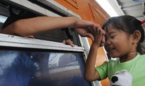 Seorang bocah mencium tangan saudaranya yang akan pergi menggunakan kereta api kelas ekonomi Gaya Baru di Stasiun Jakarta Kota, Jakarta Barat, Senin (22/8). Mulai 23 Agustus hingga 3 September 2011, kereta api kelas ekonomi angkutan Lebaran dari Jakarta ha