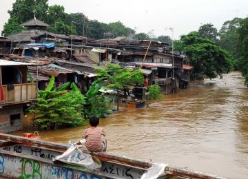 Seorang bocah tengah melihat luapan Kali Ciliwung yang membuat banjir dikawasan Kampung Melayu Kecil, jakarta Selatan, Kamis (23/2). (Republika/Agung Supriyanto)