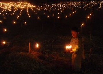 Seorang bocah tengah memasang lampu dalam perayaan Tumbilotihe di Gorontalo.