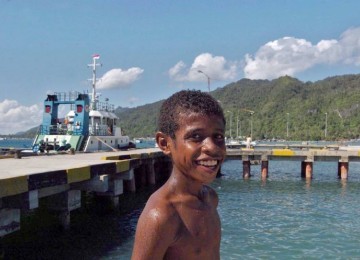 Seorang bocah tersenyum saat bermain dipantai Kaimana, Papua, Selasa (9/1). Pesona keindahan alam serta objek wisata pantai merupakan salah satu sumber daya kabupaten Kaimana yang berada di kepala burung Papua.