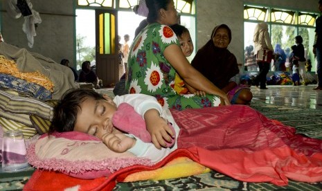 Seorang bocah tertidur lelap di posko pengungsian korban banjir bandang di masjid Baitul Hamid di Kelurahan Penaraga, Kota Bima, NTB, Senin (26/12).