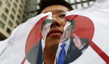 Seorang demonstran Korea Selatan (Korsel) merobek foto Perdana Menteri Jepang Shinzo Abe di depan Kedubes Jepang di Seoul, Rabu (17/7). Protes dilakukan mengecam keputusan Jepang membatasi ekspor ke Korsel.