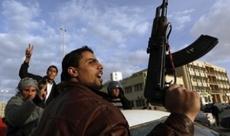 Seorang demonstran Libya membawa senjata, meneriakkan slogan-slogan antipemerintah dan anti-Gaddafi