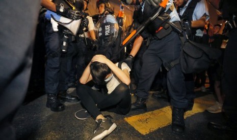 Seorang demonstran melindungi dirinya dari polisi Hong Kong saat protes menentang hukum ekstradisi di Hong Kong, Senin dini hari (10/6).