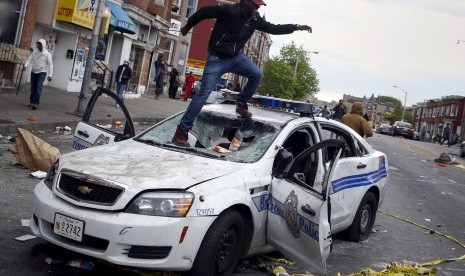 Seorang demonstran merusak mobil polisi di Baltimore, Maryland, AS, Senin (27/4)